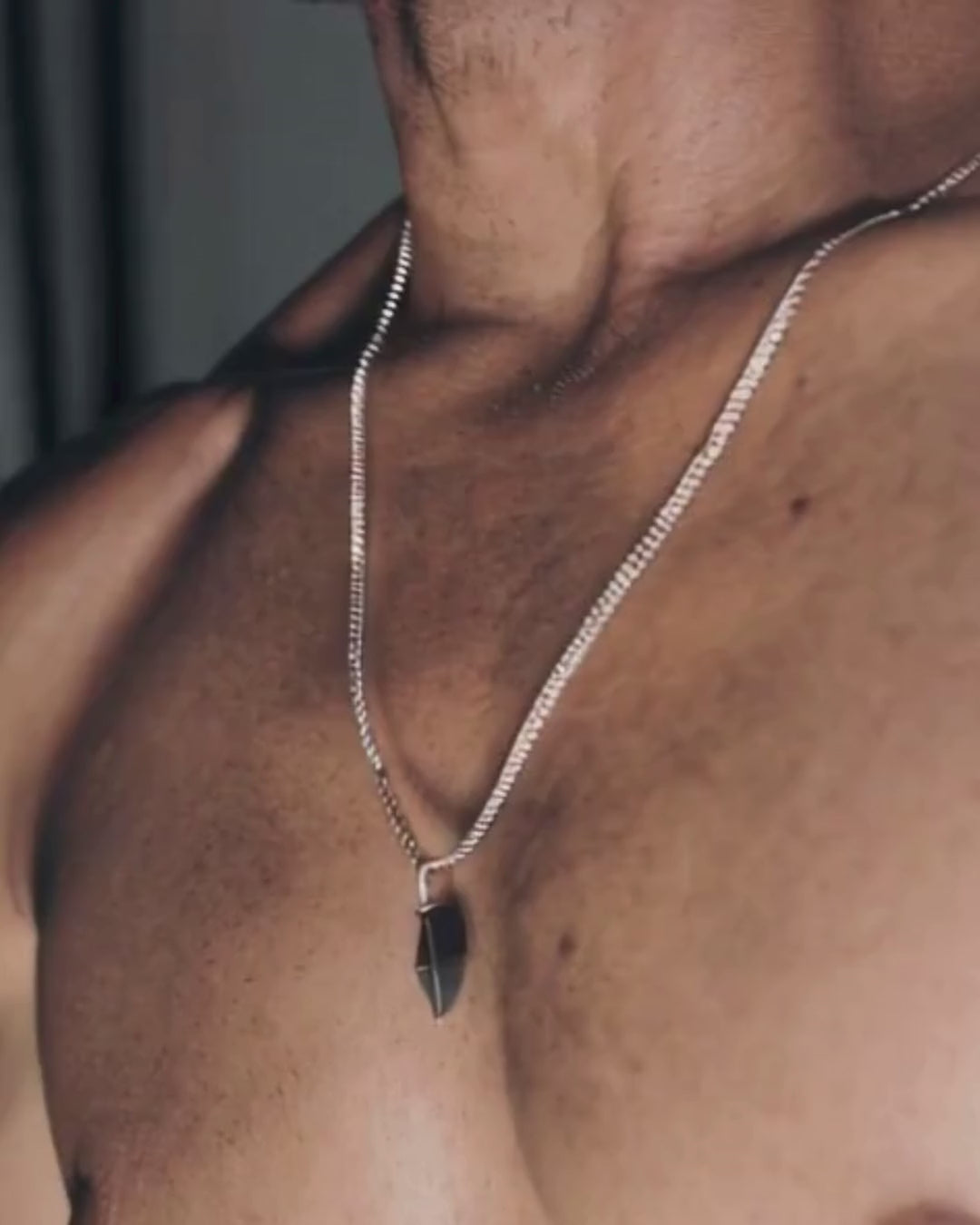 mann trägt hämatit stein kette aus silber. muskulös